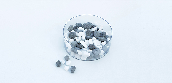 Schritt 2 Schale mit weißen und grauen ovalen Bonbons auf weißem Hintergrund