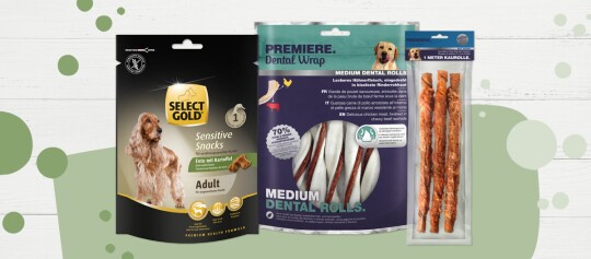 Trois paquets différents de friandises pour chiens – SELECT GOLD Sensitive Snacks au canard et pommes de terre, PREMIERE Dental Wrap rouleaux dentaires moyens au poulet et peau de bœuf, et un rouleau à mâcher d’un mètre.