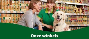 Twee vrouwen en een blije golden retriever in een dierenwinkel voor schappen met dierenvoer – vriendelijke service in onze winkels