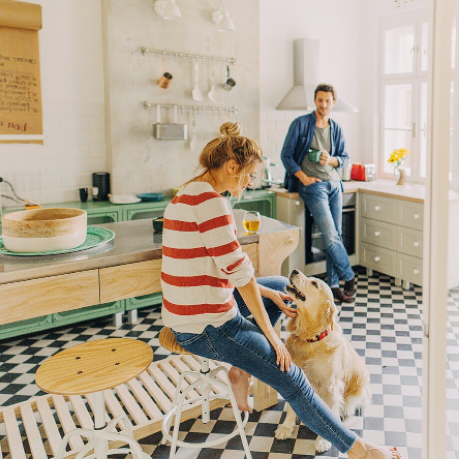 Ein Mann und eine Frau mit einem Hund in der Küche