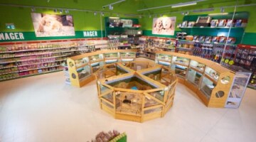 Intérieur d'un magasin d'animaux avec enclos pour rongeurs et étagères remplies d'accessoires pour petits animaux