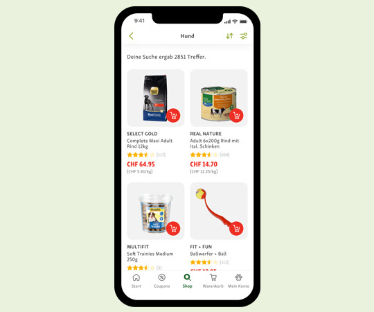 Smartphone-Bildschirm mit einer Haustier-Shop-App, die Hundefutter und Hundespielzeug anzeigt, inklusive SELECT GOLD Trockenfutter, REAL NATURE Nassfutter, MULTIFIT Leckerlis und FIT + FUN Ballwerfer.