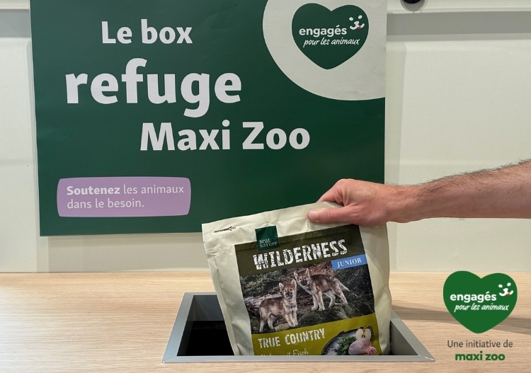 Box Refuges_2024 Main déposant une nourriture pour animaux Wilderness Junior dans la boîte refuge Maxi Zoo, soutien aux animaux dans le besoin