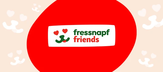 Fressnapf Friends Logo mit roten Herzen und stilisiertem Tiergesicht auf rotem Kreis vor hellem Hintergrund mit Tiermotiven