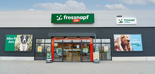 Außenansicht eines fressnapf XXL Tierfachgeschäfts mit Werbetafeln für Tierbedarf und Fellpflege