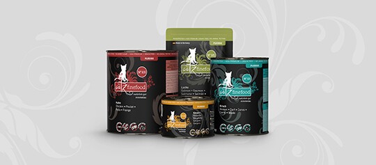 Felinefood Katzenfutter in verschiedenen Sorten in schwarzen Verpackungen mit roten, grünen, blauen und orangen Akzenten vor grauem Hintergrund