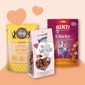 Drei verschiedene natürliche Haustierfutter-Packungen für Katzen und Hunde, darunter Kitty's Cuisine Huhn, Bunny My Little Sweetheart Beeren-Leckerlis und Rinti Chicko Plus Hühner-Käse Hundesnack.
