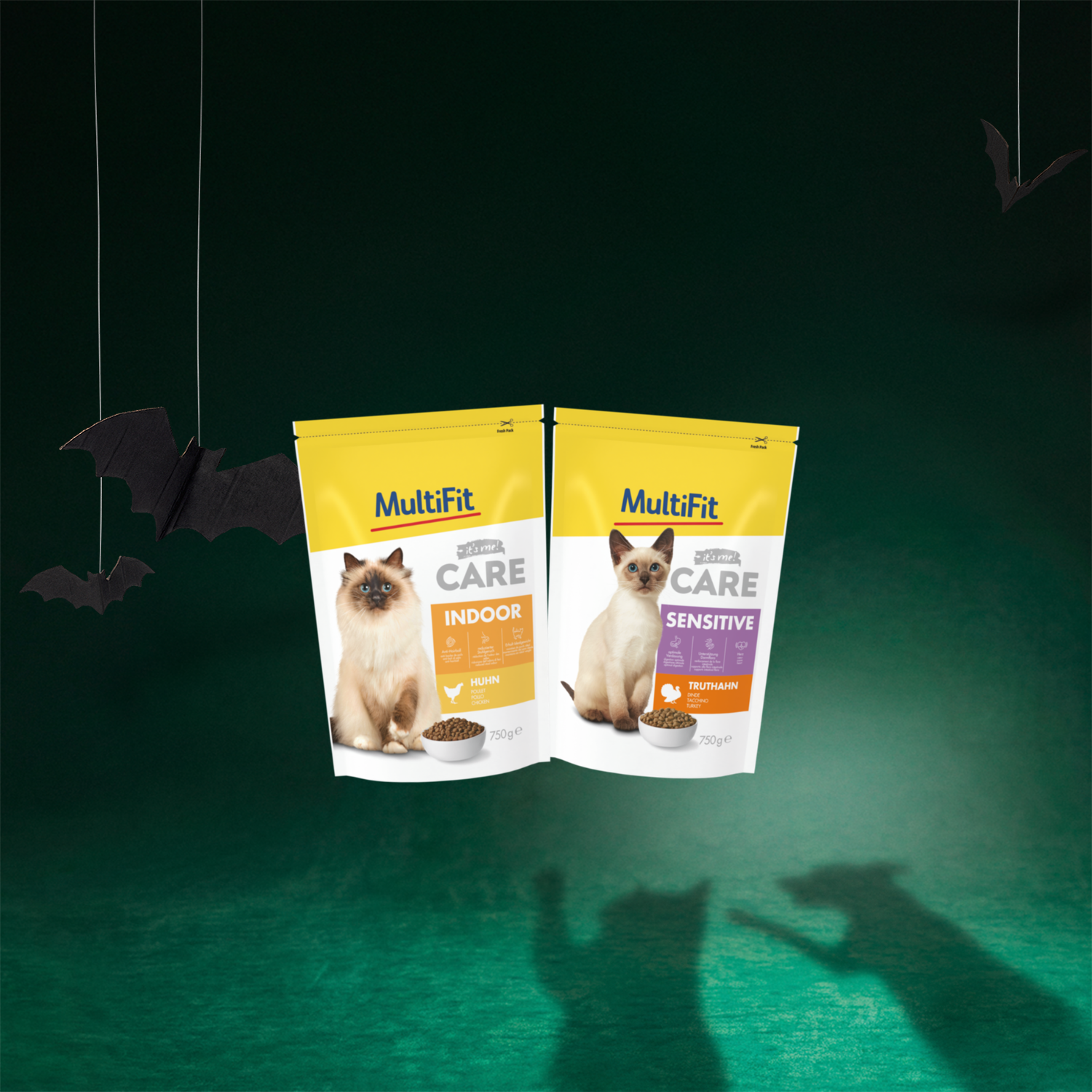 On voit ici deux paquets de croquettes pour chat de 750 g, dans les variétés « Indoor Poulet » et « Sensitive Dinde » de la marque MultiFit Care.