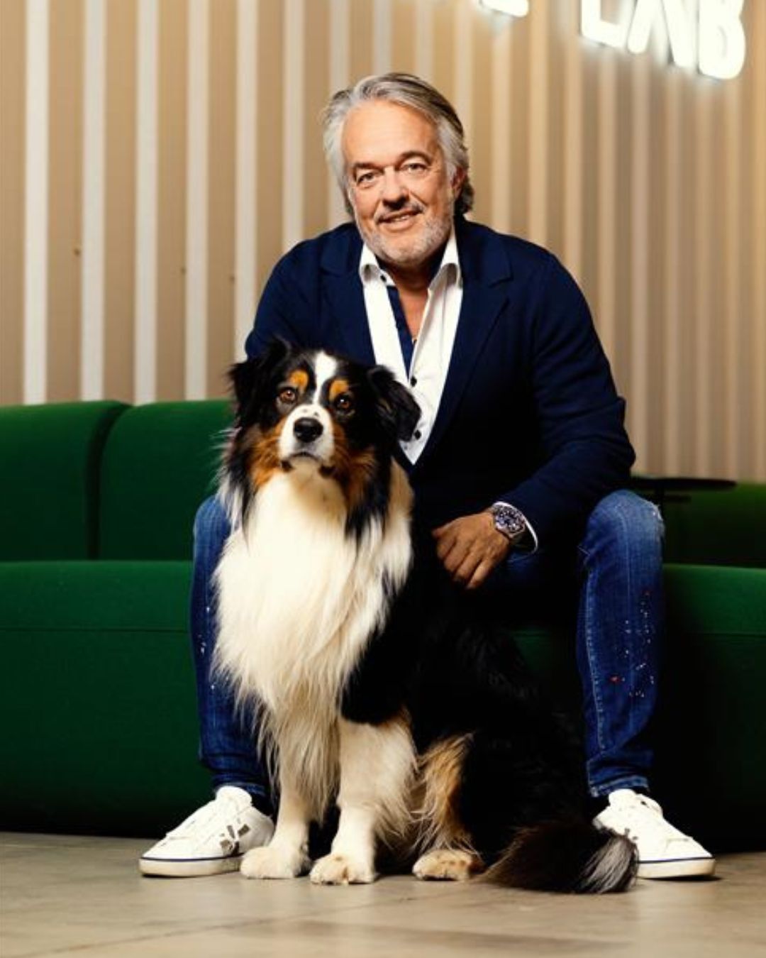 Torsten Toeller, der Gründer von Fressnapf | Maxi Zoo sitzt auf einem Sofa und streichelt einen Hund.
