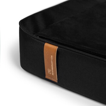 Schwarzes Haustierbett mit glatter Oberflächenstruktur und einem Lederschild, auf dem "REXPRODUCT.COM" steht.