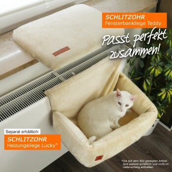 Eine weiße Katze liegt in einem beigen Haustierbett neben einem Heizkörper, mit einem weiteren Bett auf der Fensterbank darüber. Der Text erwähnt SCHLITZOHR Produkte.
