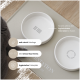 Zwei weiße Keramik-Katzenfutterschalen auf einer beigen Matte mit der Aufschrift "KATZENFUTTER", mit rutschfester und hygienischer Gestaltung.