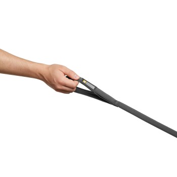 Eine Hand hält eine graue Hundeleine mit einem Etikett, das "Ruffwear" auf einem weißen Hintergrund liest.