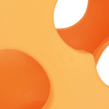 Nahaufnahme eines leuchtend orangefarbenen Hundespiels mit mehreren Löchern, entworfen zum Kauen und Spielen.