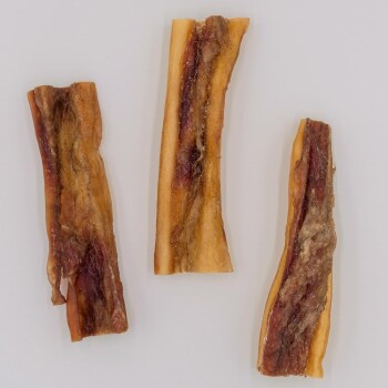 Drei Hundekauartikel aus getrocknetem Fleisch, auf einem hellen Hintergrund präsentiert.