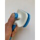 Eine Hand hält ein blau-weißes Haustierpflegewerkzeug mit einem strukturierten Griff und einem kammartigen Kopf, vor einem schlichten Hintergrund.
