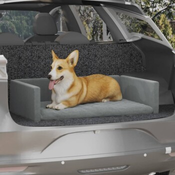 Ein glücklicher Corgi, der auf einem grauen Haustiersitz im Rücksitz eines Autos liegt, mit einem strukturierten schwarzen Hintergrund.