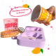 Hand hält einen orangefarbenen ICE ICE Buddy Hundeeisbecher über einer lila pfotenförmigen Form mit Holzstielen, Text "Einfaches Anrühren im Becher!"