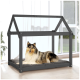Ein Collie liegt auf einem gemütlichen grauen Haustierbett in einem stilvollen Holz-Hundehäuschen mit Dach, in einem hellen Raum mit großen Fenstern.