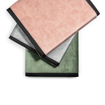 Drei Haustierdecken, die übereinander gestapelt sind, in rosa, grau und grün, jede mit einem schwarzen Rand.