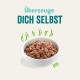 Schüssel mit Haustierfutter, gefüllt mit einer Mischung aus Fleisch und Gemüse, mit dem Text 'Überzeuge DICH SELBST' darüber.