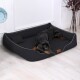 Ein schwarzes Hundebett, auf dem ein Dobermann bequem liegt, mit einem kleinen Kissen und einem Lederetikett an der Seite.