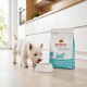 Weißer West Highland Terrier schnüffelt an einer leeren Schüssel neben einem Sack mit hypoallergenem Hundefutter von Select Gold Medica