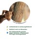 Ein brauner Hund schaut neugierig auf einen strukturierten Baumstamm, mit Text, der die antibakteriellen und verdauungsfördernden Vorteile der Baumrinde hervorhebt.
