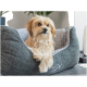 Ein flauschiger Hund ruht sich bequem in einem stilvollen grauen Haustierbett mit einem gesteppten Innenraum aus, das ein gemütliches und modernes Design zeigt.