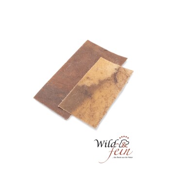 Zwei Stücke natürlicher Haustierleckerlis in verschiedenen Brauntönen, mit dem Logo "Wild & fein" und dem Slogan "... das Beste aus der Natur" sichtbar.