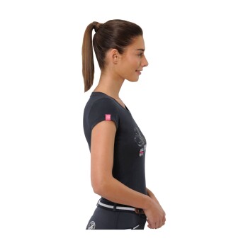 Eine Frau in einem schwarzen T-Shirt mit einem Hasenmotiv und einem rosa Etikett, die einen Gürtel mit einem weißen Streifen trägt, steht im Profil.