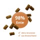 Braune Enten-Kibble-Pellets um einen orangefarbenen Kreis mit der Aufschrift '98% Ente', Häkchen mit 'ohne Innereien' und 'aus Deutschland'