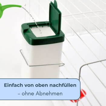 Futterspender für Haustiere mit grünem Klappdeckel wird befüllt; deutscher Text: „Einfach von oben nachfüllen – ohne Abnehmen“.