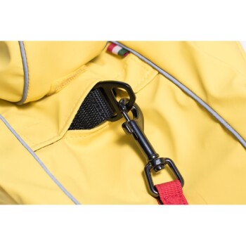 Nahaufnahme eines gelben Haustiergeschirrs mit einem schwarzen Clip und rotem Riemen, das den Befestigungspunkt und die Nähdetails zeigt.