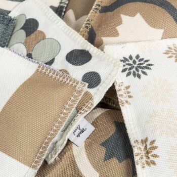 Nahaufnahme von Stoffmustern mit verspielten erdigen Mustern, einschließlich Punkten und Blumen, beschriftet mit "Made in".