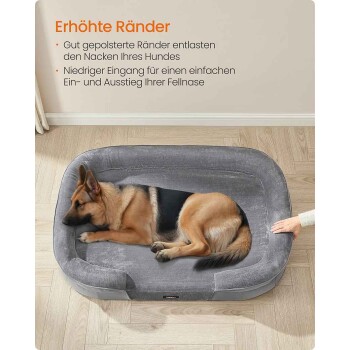 Deutscher Schäferhund auf grauem Hundebett mit erhöhtem Rand auf Holzfußboden, Hand berührt das Bett; deutsche Überschrift 'Erhöhte Ränder' sichtbar