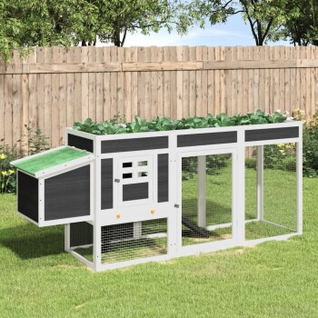 Ein geräumiger Außenbereich für Haustiere mit grünem Dach, Holzstruktur und Drahtgitterseiten, in einem grasbewachsenen Garten.