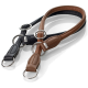 Zwei Leder-Hundeleinen, eine schwarz und eine braun, mit silbernen Metallringen und einem Logotag, auf einem weißen Hintergrund präsentiert.