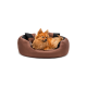 Ein flauschiger Pomeranian-Hund entspannt sich in einem runden, braunen Haustierbett mit schwarzen Akzenten und sieht zufrieden und entspannt aus.