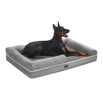 Dobermann ruht auf grauem Hundebett mit erhöhtem Rand, Innenfläche aus flauschigem Shag-Plüsch und sichtbarem Feandrea-Etikett.