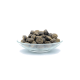 Eine Glasschüssel gefüllt mit kleinen, runden, dunklen Haustierfutterpellets, vor einem weißen Hintergrund.
