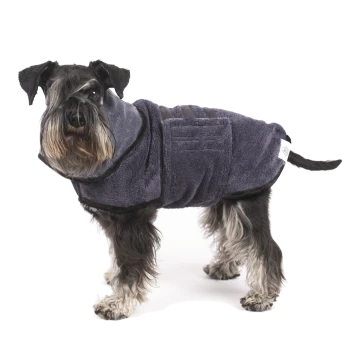Ein stilvoller Schnauzer trägt einen dunkelblauen Haustierhandtuchmantel, steht vor einem weißen Hintergrund und zeigt sein flauschiges Fell und seinen wachsamen Ausdruck.