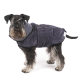 Ein stilvoller Schnauzer trägt einen dunkelblauen Haustierhandtuchmantel, steht vor einem weißen Hintergrund und zeigt sein flauschiges Fell und seinen wachsamen Ausdruck.