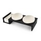 Moderne schwarze Futterstation für Haustiere mit zwei weißen Keramikschalen und einem kleinen Fach zur Aufbewahrung.