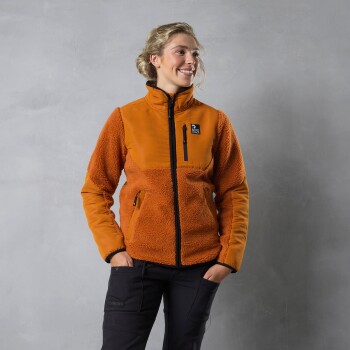 Eine Person in einer orangefarbenen Fleecejacke mit einer Reißverschlusstasche steht vor einem grauen Hintergrund und präsentiert eine stilvolle Haustierbekleidungsoption.