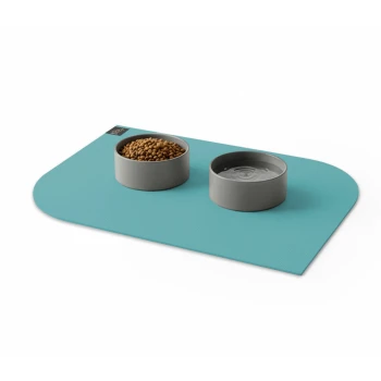 Graue Futter- und Wassernäpfe auf einer blauen rechteckigen Matte mit einem kleinen schwarzen und goldenen Etikett.