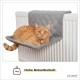 Eine entspannte orangefarbene getigerte Katze liegt auf einem grauen, gesteppten Heizkörperbett, mit dem Text darunter "Hohe Belastbarkeit" und einem Gewichtssymbol, das 7 kg anzeigt.