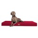 Ein grauer Weimaraner-Hund liegt auf einem roten Haustierbett und schaut aufmerksam zur Seite, mit einem kleinen Logo an der Seite des Bettes.