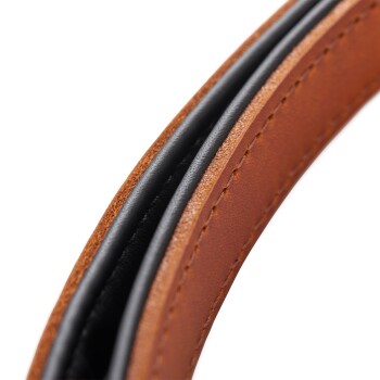 Nahaufnahme eines braunen und schwarzen Leder-Hundehalsbands, das detaillierte Nähte und eine glatte Oberfläche zeigt.