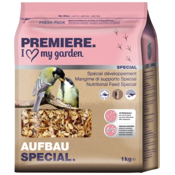 Ein 1 kg Sack Vogelfutter mit zwei kleinen Vögeln auf einem Ast, Hafer und Mehlwürmern. Der Text lautet "PREMIERE. I ♥ meinen Garten" und "AUFBAU SPECIAL."